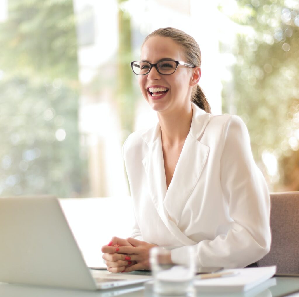 laughing businesswoman working in office with laptop
